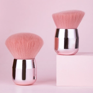 Detail of pink mushroom head loose powder and angled contour brushes with rose gold handles