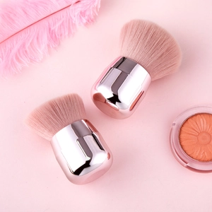 Macro shot of two professional pink fiber makeup brushes with rose gold metal handles