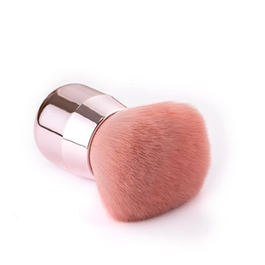 Close-up of soft pink mushroom head makeup brush with rose gold metallic handle