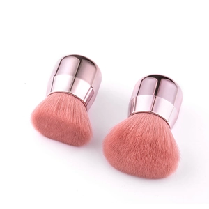 Detail of pink fiber mushroom powder brushes with rose gold metallic handles for makeup
