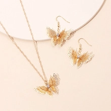 Detailed close-up of hollow butterfly jewelry set with rhinestones and gold finish