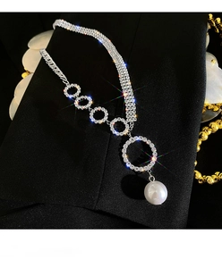 Detailed close-up of sparkling rhinestone choker necklace with a large white pearl pendant