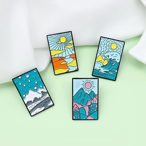 Set of four seasons enamel brooches featuring landscape sunrise and mountain designs