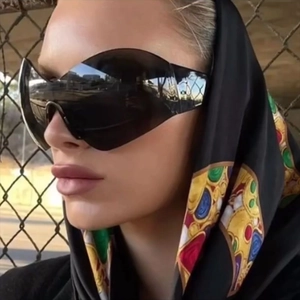 Y2K futuristic rimless wraparound sunglasses with black lenses on fashion model