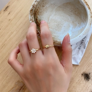 Detail of 925 silver minimalist rings with gold flower and star disc charms on hands