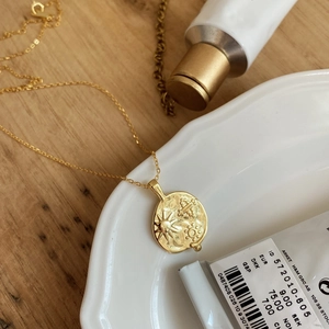 925 silver sun celestial coin pendant necklace on a minimalist ceramic plate display
