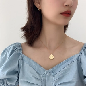 Chic 925 silver sun and planet coin pendant necklace worn by a model in a minimal setting
