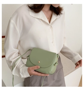 Detail of light green crossbody bag featuring golden hardware and fine stitching