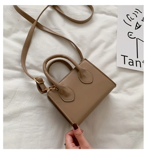 Detailansicht einer khakifarbenen Mini-Umhängetasche mit Ledertextur und Goldschnalle
