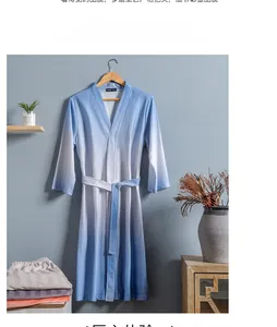 Detail of light blue gradient waffle texture bathrobe with tie-belt on wooden hanger