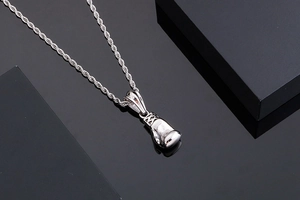 Polished silver boxing glove pendant with durable rope chain on dark background