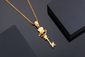 Macro shot of gold skull key pendant with top hat and sparkling crystal details