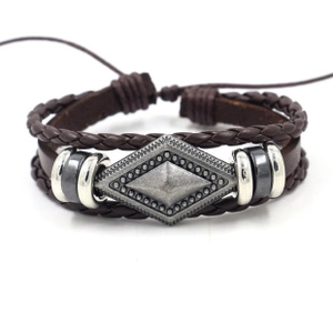 Dettaglio del bracciale multistrato in pelle marrone scuro con cordini intrecciati e perle