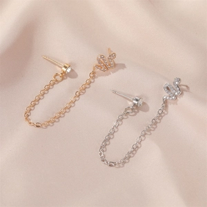 Macro detail of gold and silver snake chain earrings with sparkling zircon stones