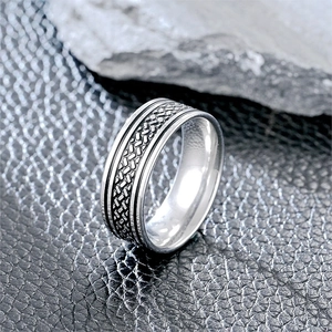 Macro detail of men's titanium steel ring featuring woven texture and polished edges