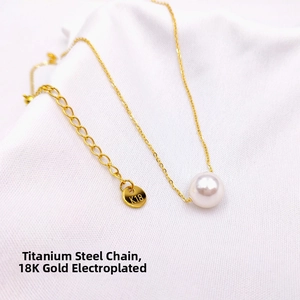 Detail view of 18K gold plated titanium necklace with K18 engraving and white pearl charm