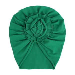 Détail du bonnet turban bébé en maille de coton vert vif avec une grande fleur plissée
