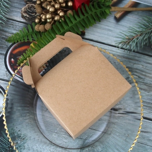 Brown kraft paper gift box with handle on decorative glass plate and festive holiday decor