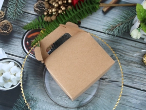 Top view of a brown kraft paper gift box with handle on a rustic wooden background