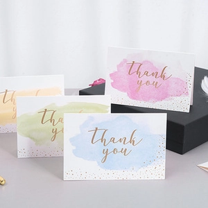 Set of four watercolor thank you cards in pink, blue, green, and yellow with gold foil text