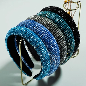 Padded crystal headbands in assorted colors displayed on a gold stand for women