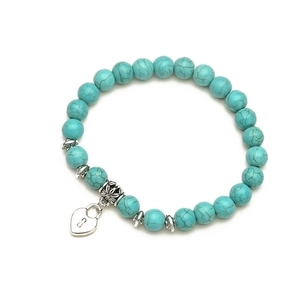 Detailed macro of turquoise beaded bracelet featuring heart lock charm and vintage spacers