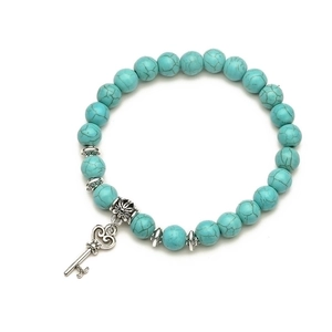 Detailed top view of turquoise beaded bracelet with silver key heart pendant and carvings