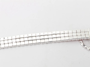 Close-up of sparkling silver pet collar with three rows of rhinestones and heart clasp