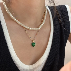 Double-layered necklace with white faux pearls and a green heart pendant for women