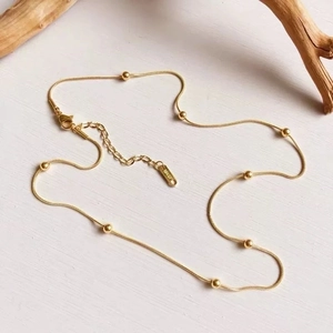 Detailed macro view of 18K gold plated lobster clasp and 18KGP engraving on snake chain