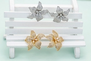 Exquisite flower stud earrings with pave cubic zirconia on a miniature bench