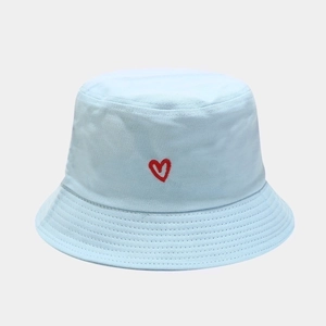 Close-up of heart embroidery on light blue cotton bucket hat with fine stitching detail