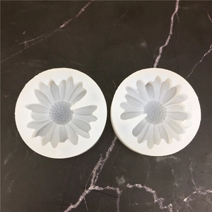 Daisy silicone mold for DIY crafts on black marble background from a top-down view