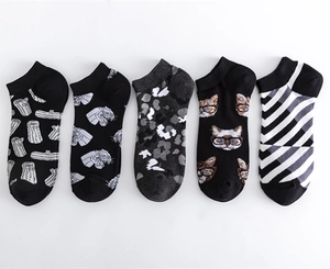 Detail view of five assorted low cut socks with geometric and character patterns