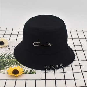 Detail of black canvas bucket hat with silver safety pin and metal rings decor