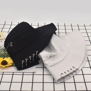 Detail of cotton bucket hats with silver metal rings and safety pin in black and white