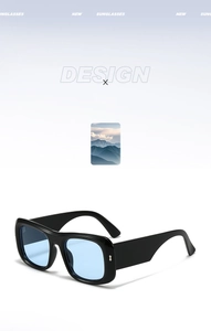 Close-up of black wide frame sunglasses with blue lenses and silver metal hinges