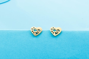 Détails de boucles d'oreilles cœur dorées avec lettrage MÃE ajouré et petits motifs cœurs