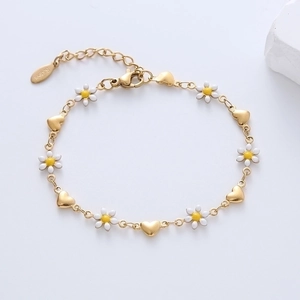 Detailed view of 18k gold plated stainless steel bracelet with daisy and heart charms