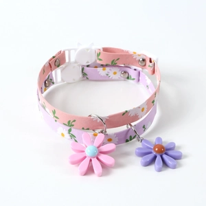 Detail of adjustable pet collars with daisy print, safety buckle and floral charm