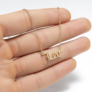 Detailed close-up of a golden Leo zodiac pendant necklace held in hand to show scale
