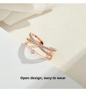 Macro detail of rose gold criss-cross ring with pavé-set stones and adjustable open band