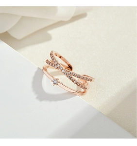 Detail shot of rose gold layered ring with zircon pavé and center stone on white block