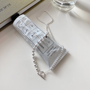 Detail of 925 sterling silver ball chain necklace featuring a modern toggle clasp closure