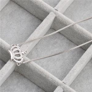 Silver crown pendant necklace with micro-set zircon on grey velvet jewelry tray