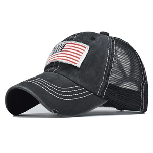 Detail of distressed brim and US flag embroidery on washed black cotton ponytail cap