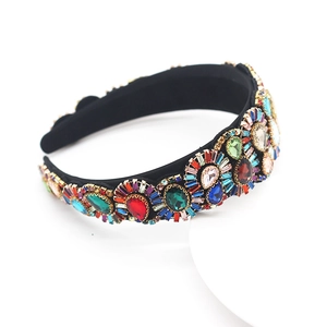 Macro detail of luxury baroque headband featuring colorful rhinestones and crystals on black fabric