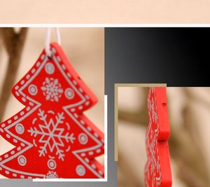 Close-up of red wooden Christmas tree ornament with delicate white snowflake patterns