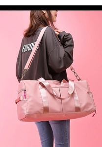 Pink waterproof fitness bag with large capacity and detachable shoulder strap on a model