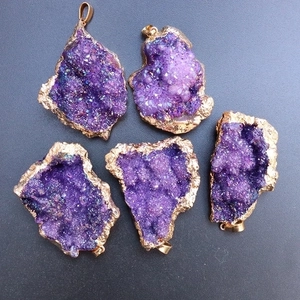 Five pieces of irregular rainbow amethyst geode pendants with gold plated edges on grey back